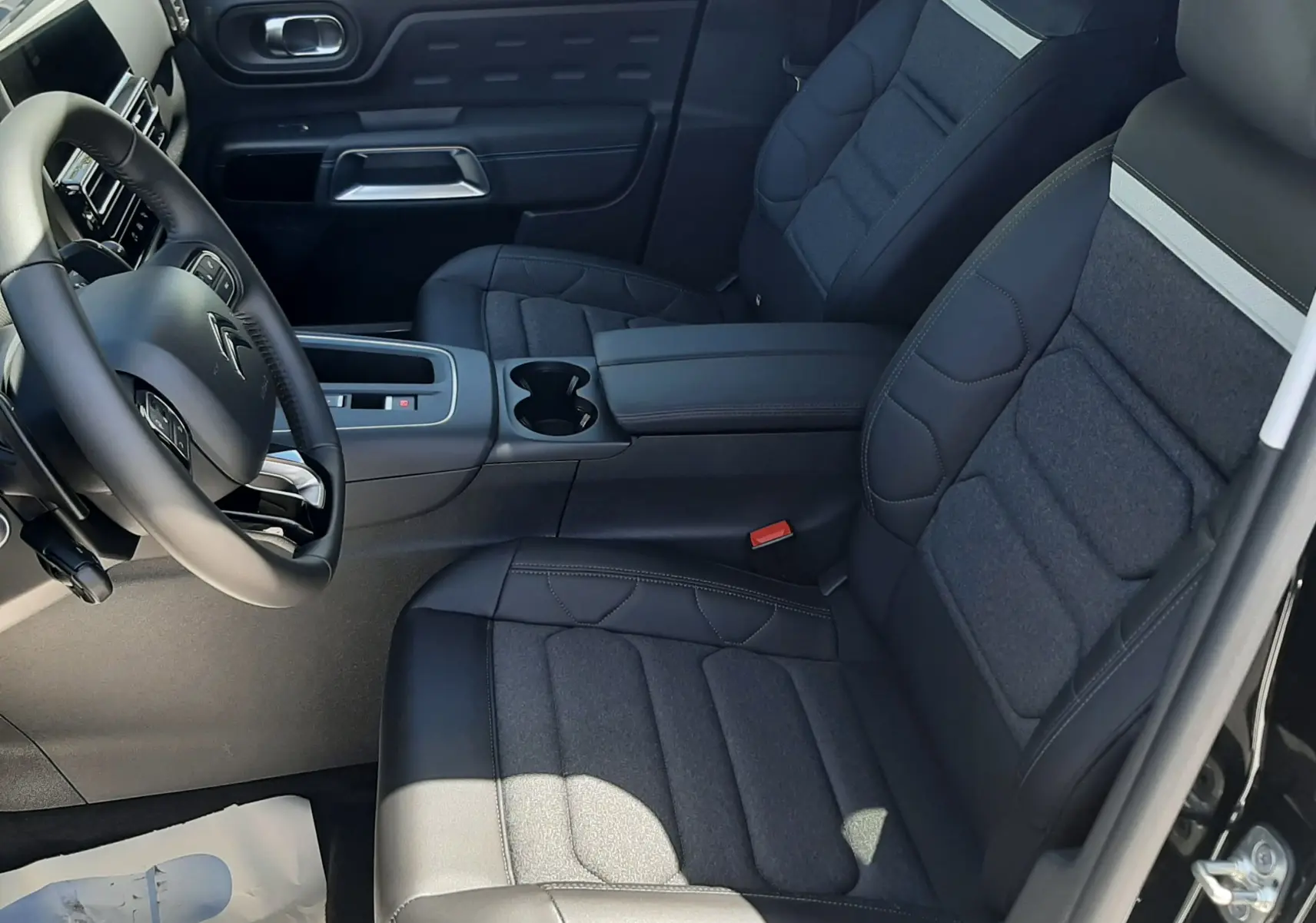 Intérieur avant droit du Citroën C5 Aircross noir Perla Nera, sièges tissu et cuir, console centrale avec porte-gobelets.