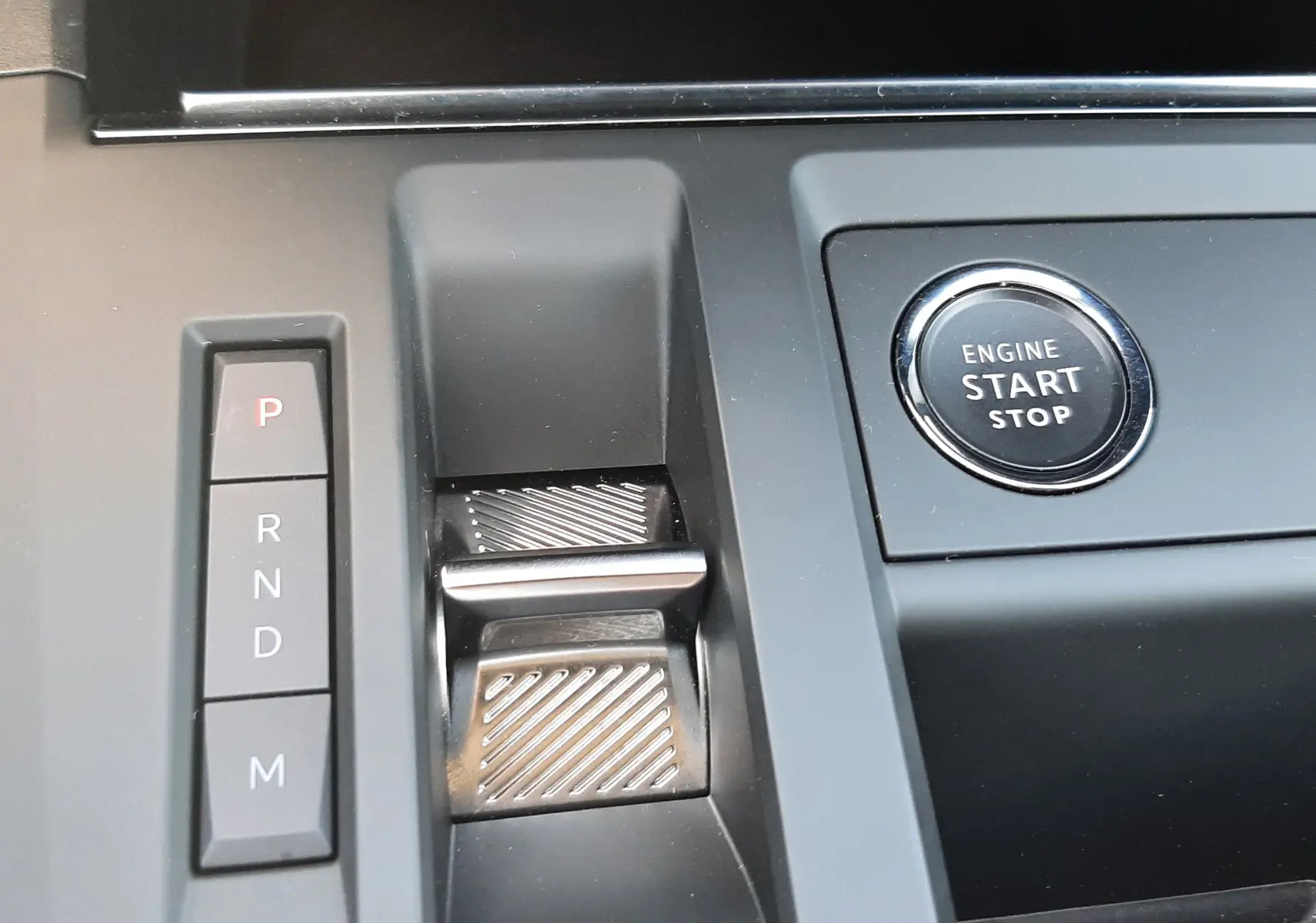 Gros plan sur la console centrale noire du Citroën C5 Aircross hybride, avec bouton start/stop et sélecteur de vitesses électronique.