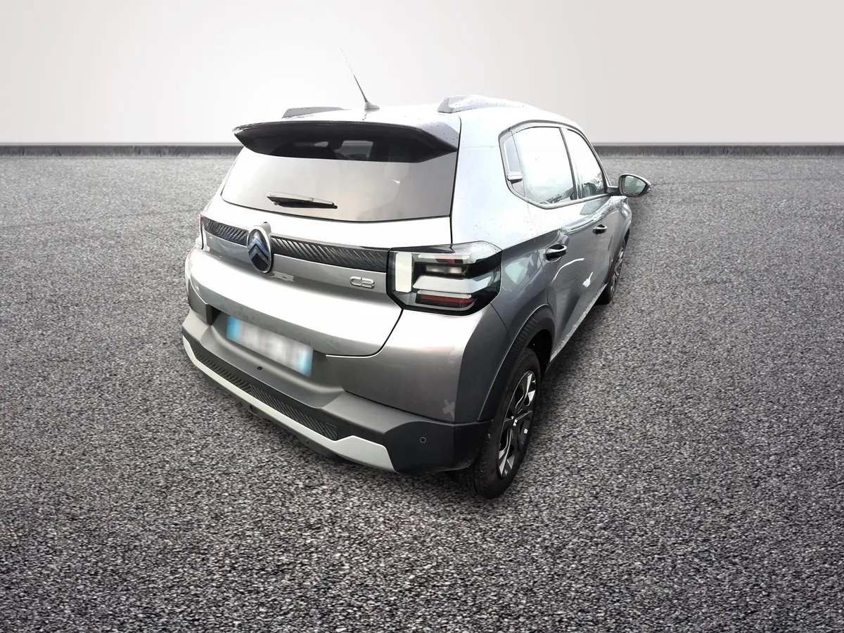 Vue 3/4 arrière droite d'une Citroën C3 Turbo 100 gris foncé avec spoiler de coffre et feux LED distinctifs.
