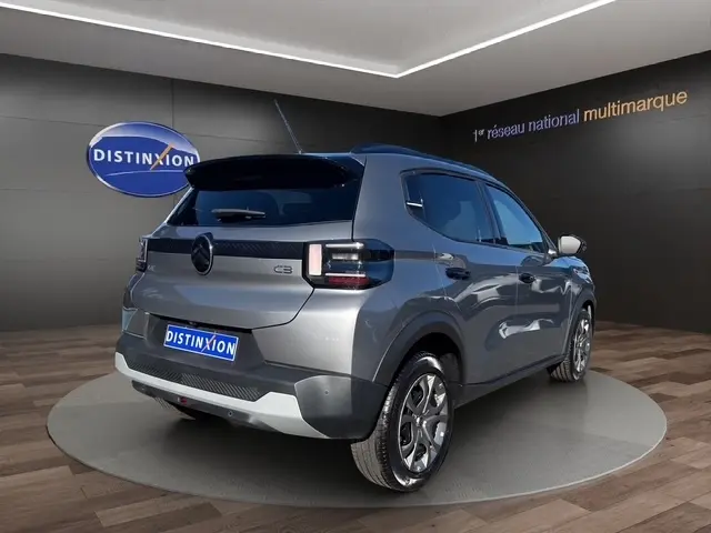 Vue 3/4 arrière droite d'une Citroën C3 gris foncé 2025 avec spoiler de coffre et feux arrière LED.