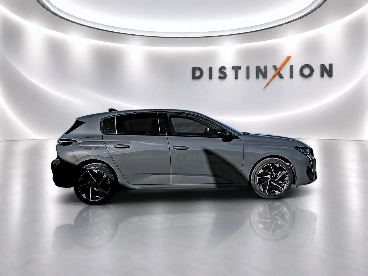 Vue de profil droit d'une Peugeot 308 gris selenium avec jantes alliage noires dans un studio lumineux.