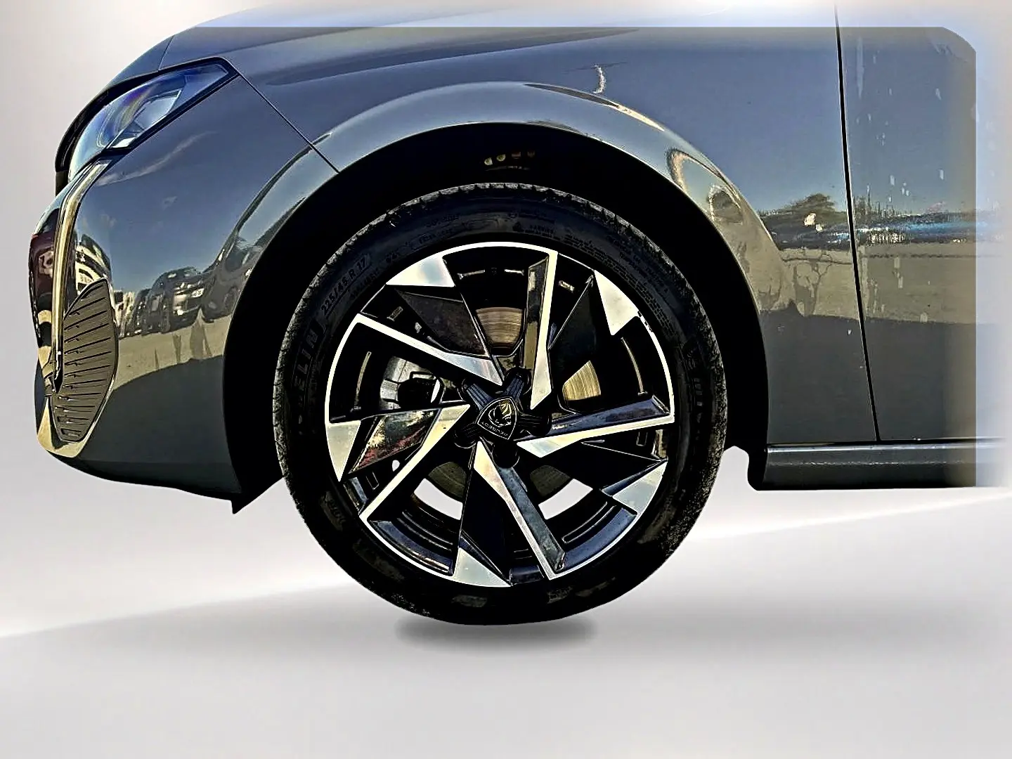 Gros plan sur la roue avant gauche et une partie de la carrosserie gris selenium de la Peugeot 308 2025.