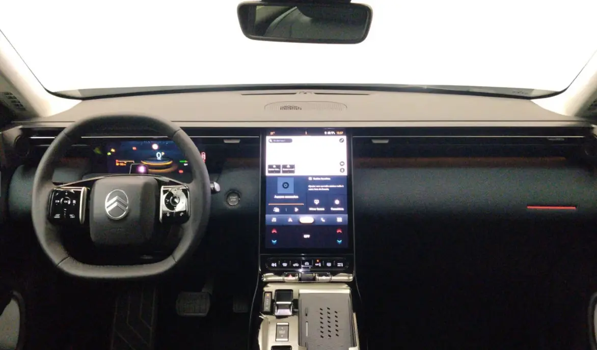 Vue intérieure frontale du tableau de bord noir de la Citroën C5 hybride avec écran tactile vertical et volant multifonctions.