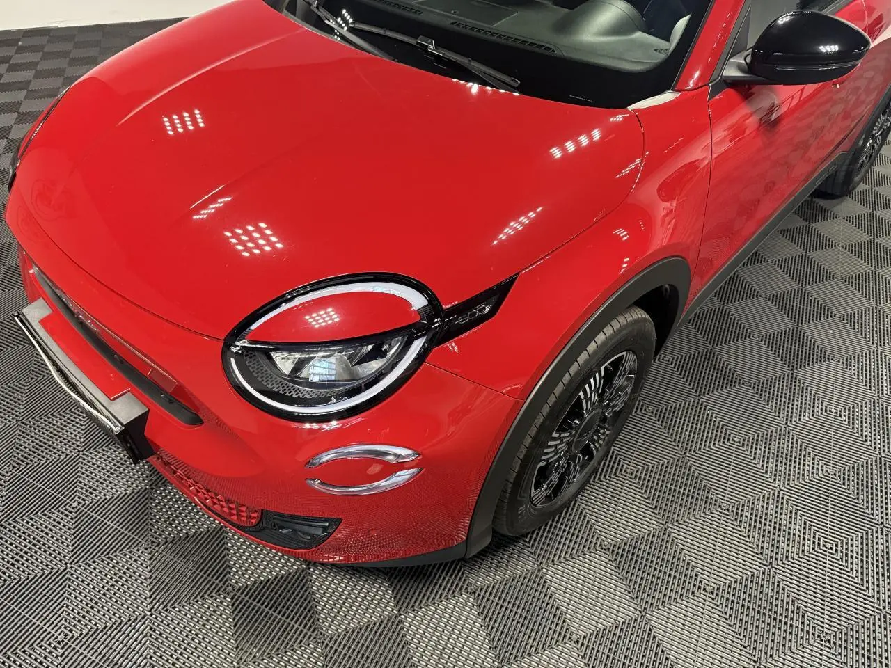 Vue 3/4 avant droit d'une FIAT 600 rouge foncé avec phares LED et coques de rétroviseurs noires brillantes.