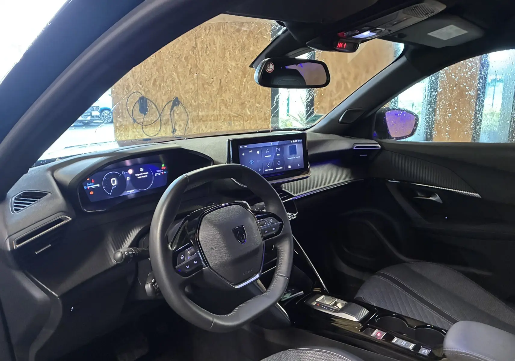 Vue intérieure côté conducteur du Peugeot 2008 1.2 Hybrid 136 Allure 2025, avec tableau de bord numérique et écran tactile central.