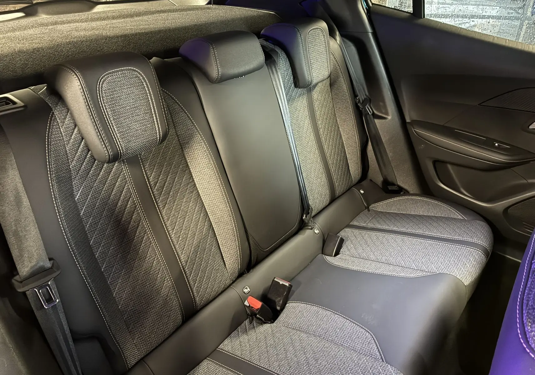Vue intérieure arrière droite des sièges arrière en tissu noir et gris du Peugeot 2008 1.2 Hybrid 136 Allure 2025.