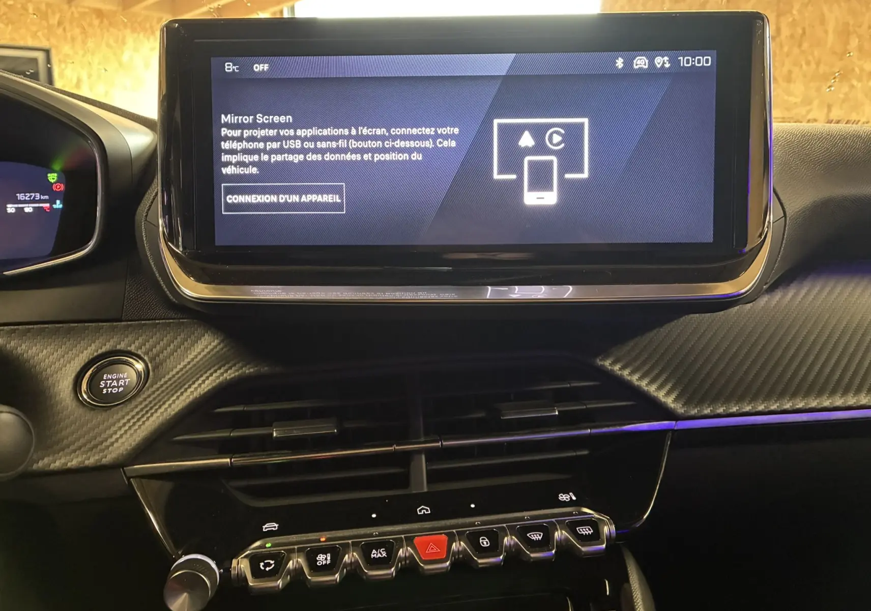 Vue rapprochée de l’écran tactile central et de la console avec boutons piano du tableau de bord noir du Peugeot 2008 bleu 2025.