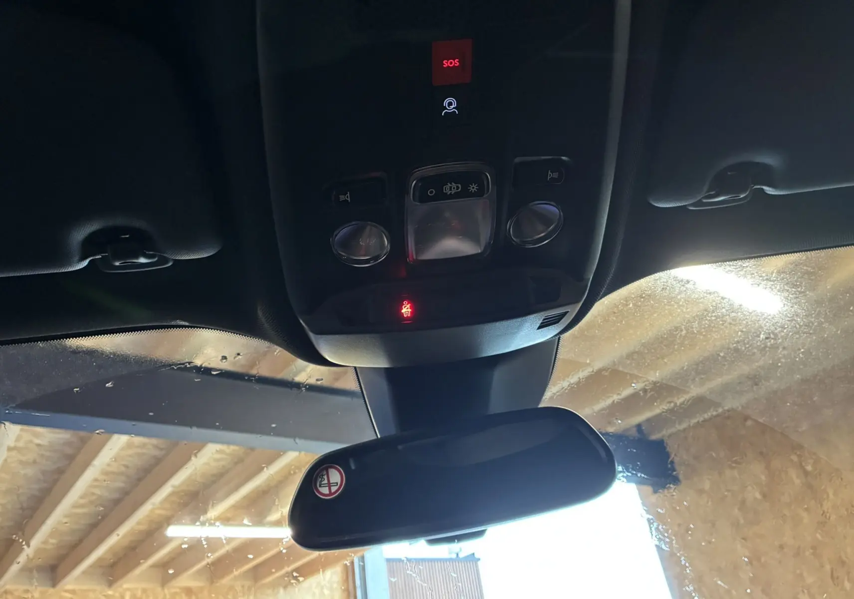 Vue intérieure du plafond avant de la Peugeot 2008 bleu 2025, montrant les commandes d'éclairage et le rétroviseur central.