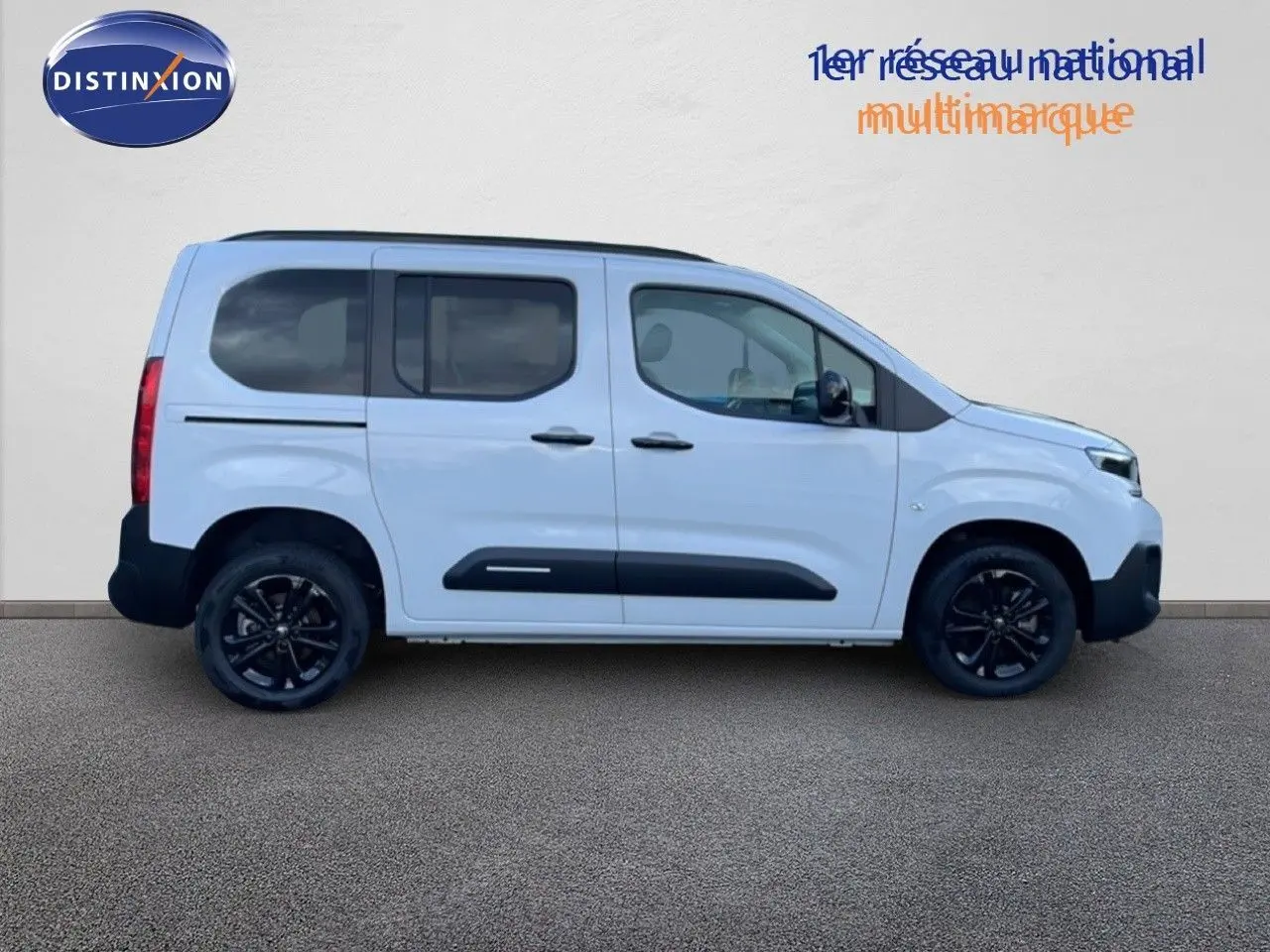 Profil droit d'un Citroën Berlingo Multispace blanc glacier avec jantes noires et protections latérales noires.