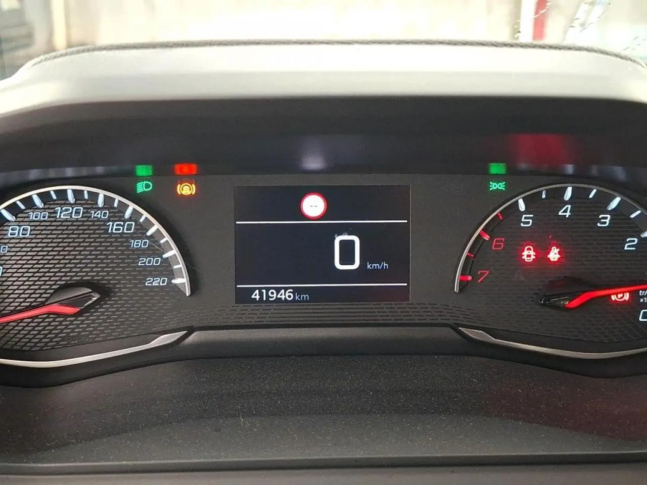 Vue rapprochée du combiné d'instruments numérique de la Peugeot 208, affichant 41 946 km et voyants allumés.