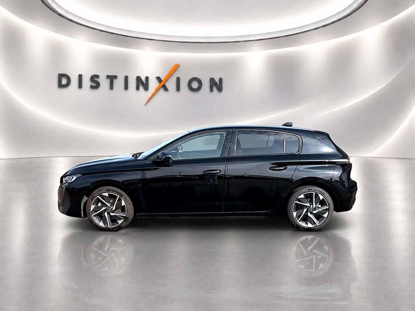 Profil côté gauche d'une Peugeot 308 noire 2025 avec jantes alu, dans un showroom au mur lumineux "DISTINXION".