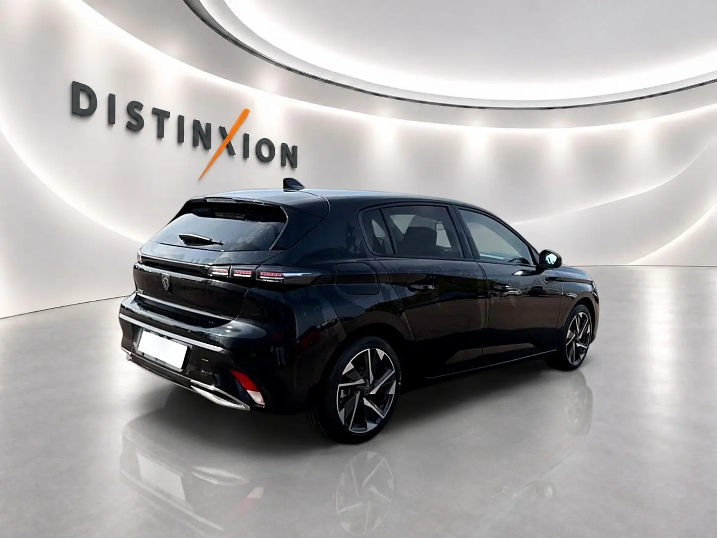 PEUGEOT 308 noir en 3/4 arrière droit dans un showroom lumineux avec jantes alliage distinctives.