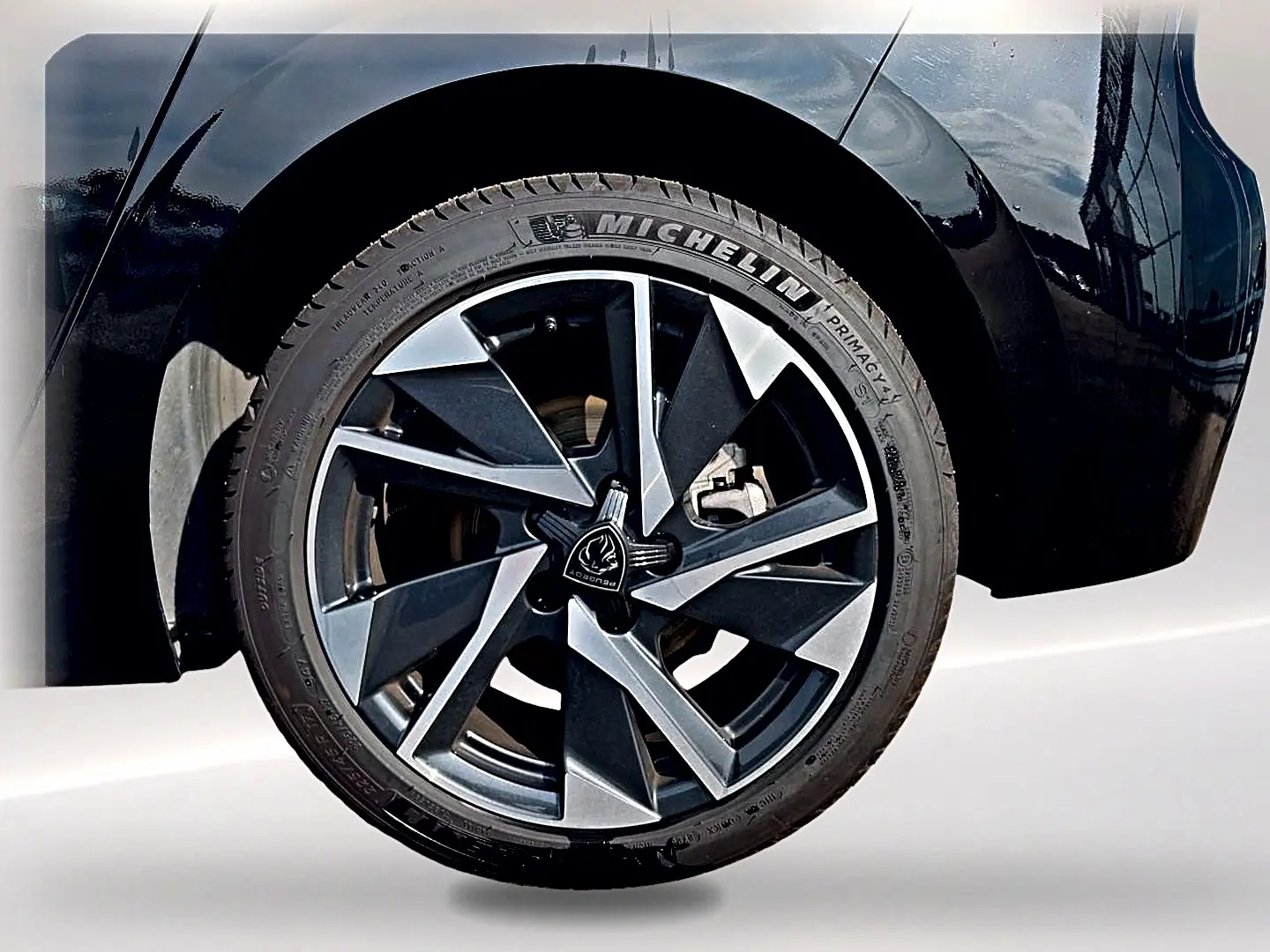 Gros plan sur la roue arrière droite noire de la Peugeot 308 2025 avec jante alu au design moderne bicolore.