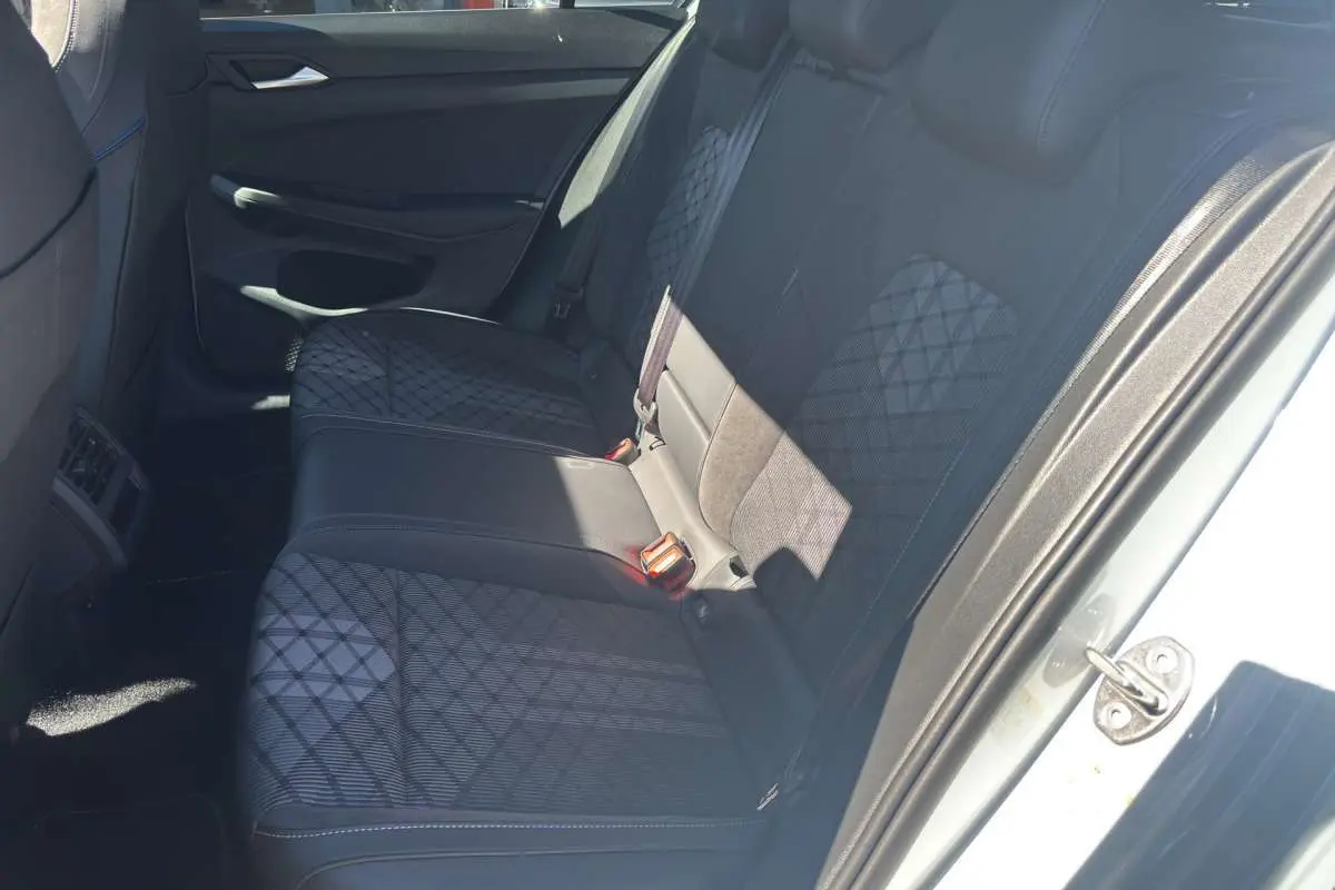 Vue intérieure côté droit sur la banquette arrière en tissu noir à motifs géométriques d'une Volkswagen Golf blanc oryx.