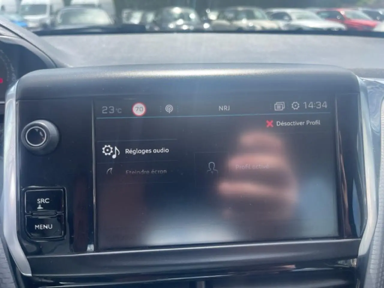 Écran tactile central de la Peugeot 208 blanc perle, affichant les réglages audio avec commandes autour.