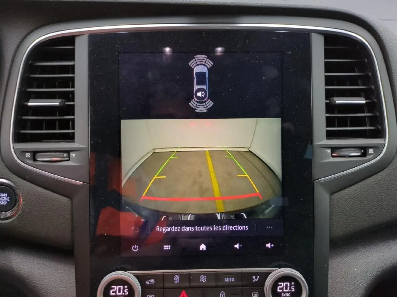 Vue rapprochée de l’écran tactile central affichant la caméra de recul de la Renault Mégane noire métal 2023.
