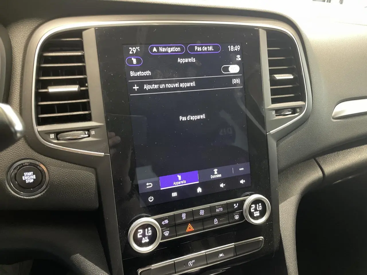 Vue rapprochée de la console centrale noire de la Renault Mégane 2023 avec écran tactile et commandes de climatisation.
