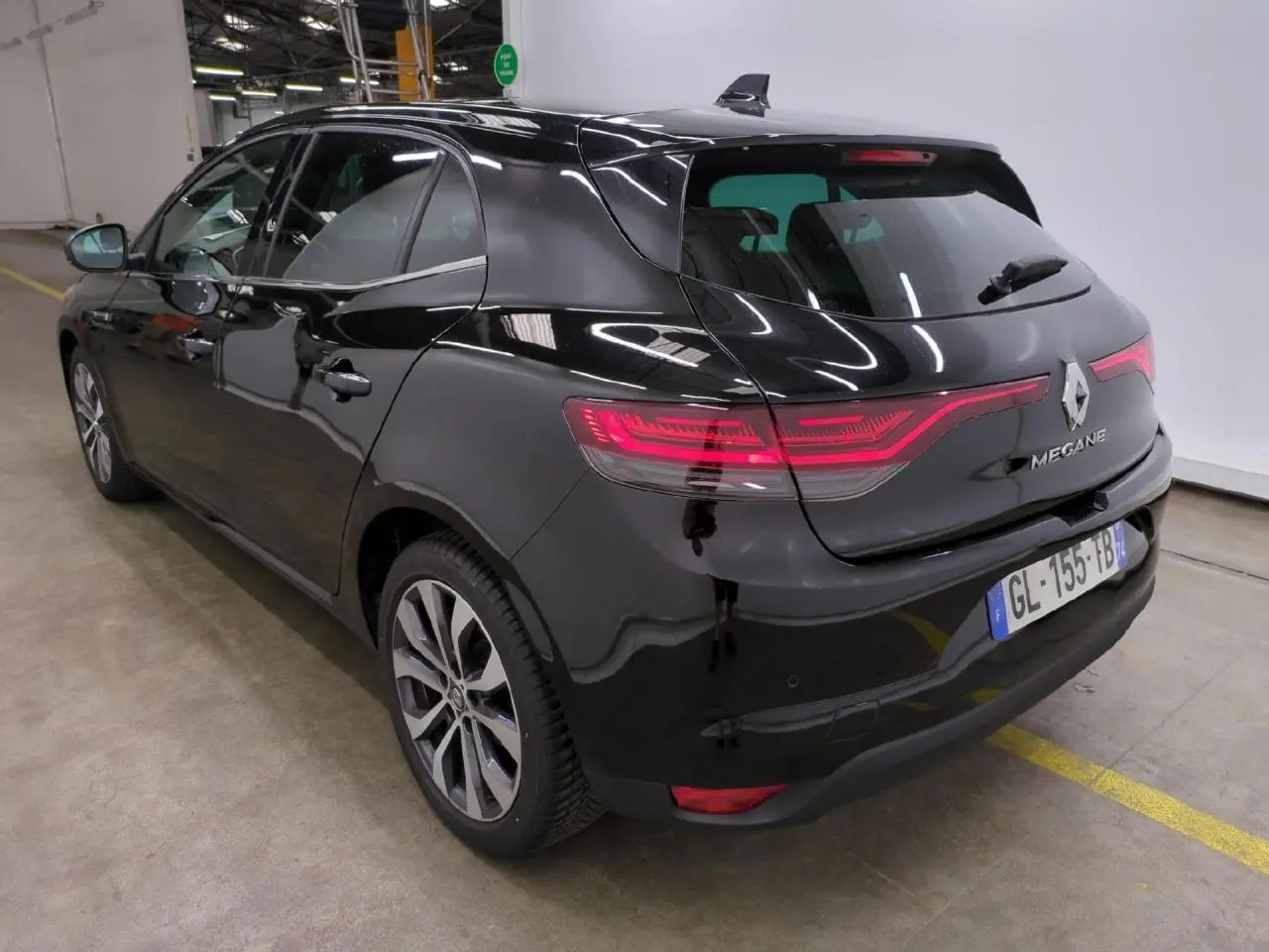 Vue 3/4 arrière droite d'une Renault Mégane noire métallisée avec feux arrière LED et jantes alliage 17 pouces.