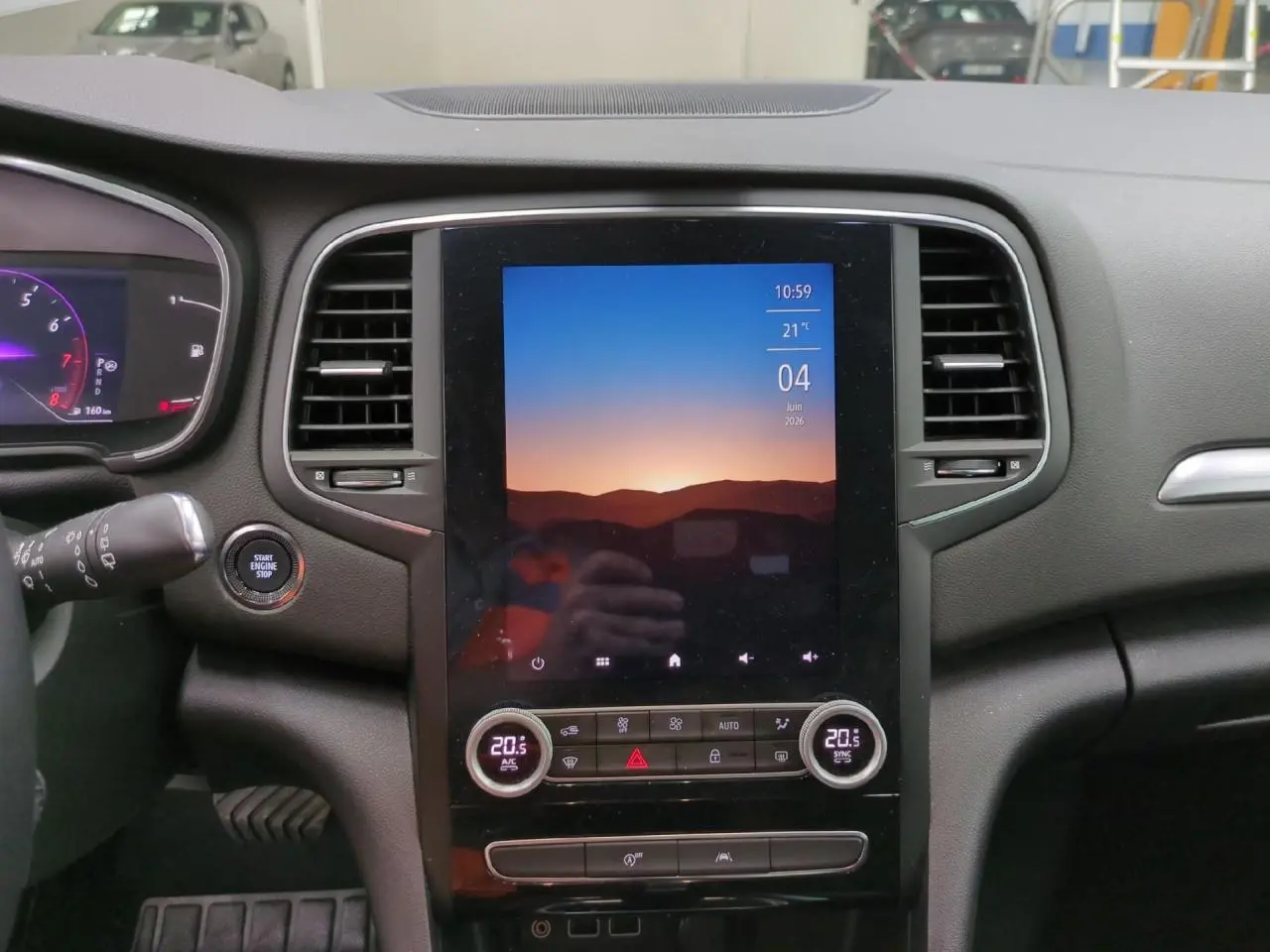 Vue rapprochée de la console centrale de la Renault Mégane 2023 avec écran tactile vertical et commandes climatisation.