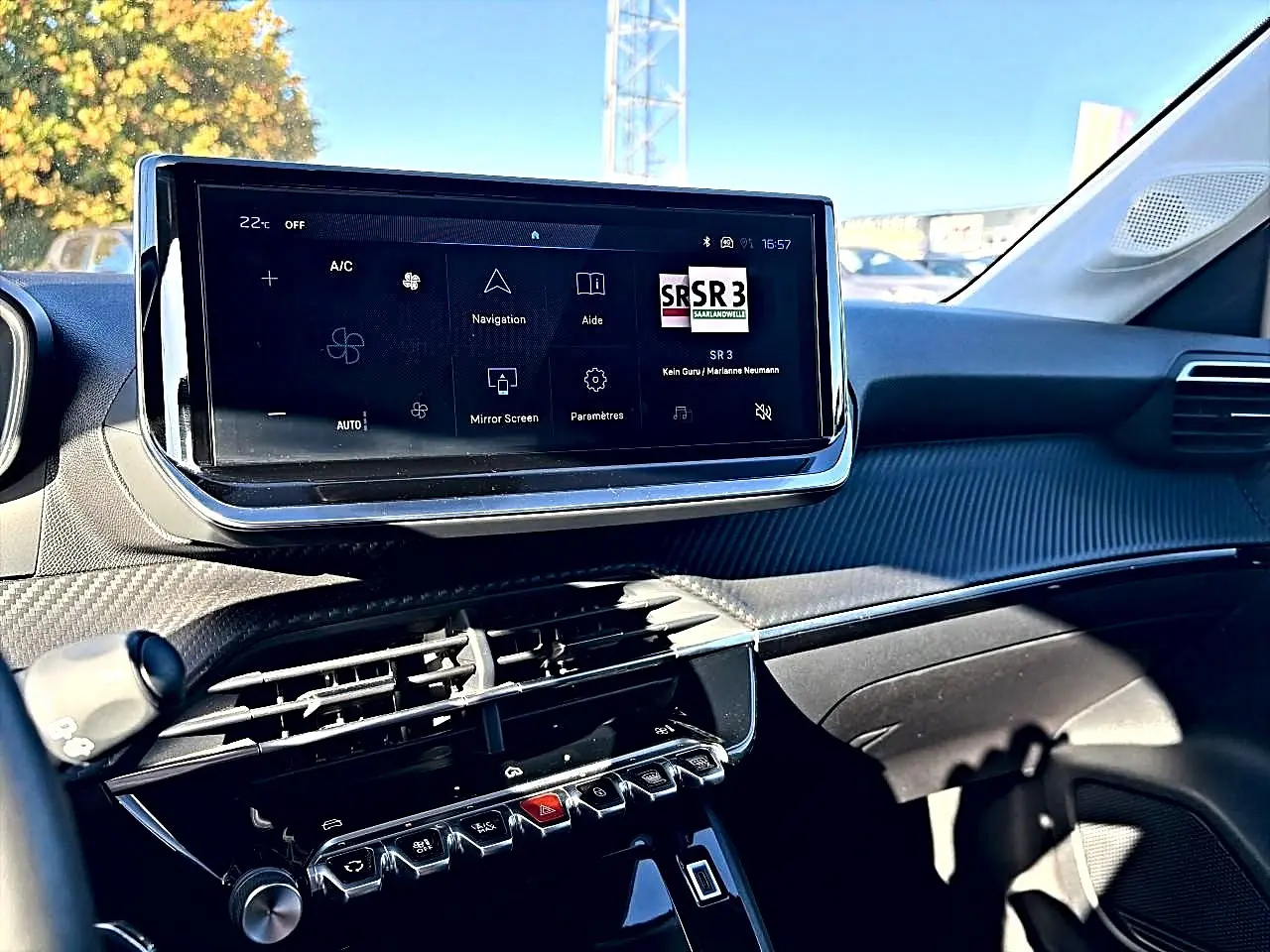 Vue intérieure du tableau de bord de la Peugeot 208 1.2 100 allure, écran tactile central et commandes piano visibles.