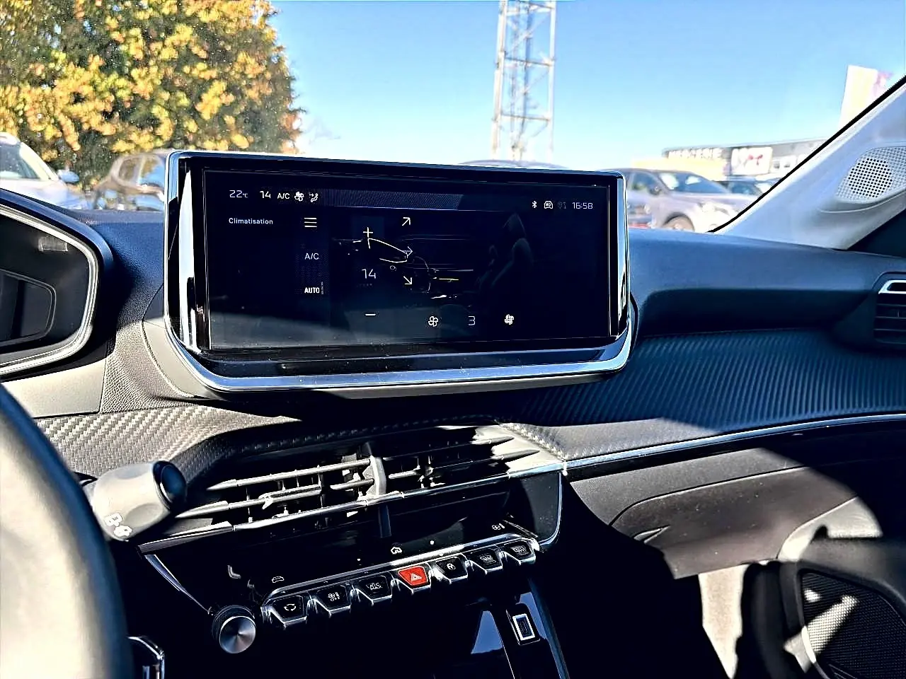 Vue intérieure du tableau de bord de la Peugeot 208 gris selenium, avec écran tactile et commandes climatisation visibles.