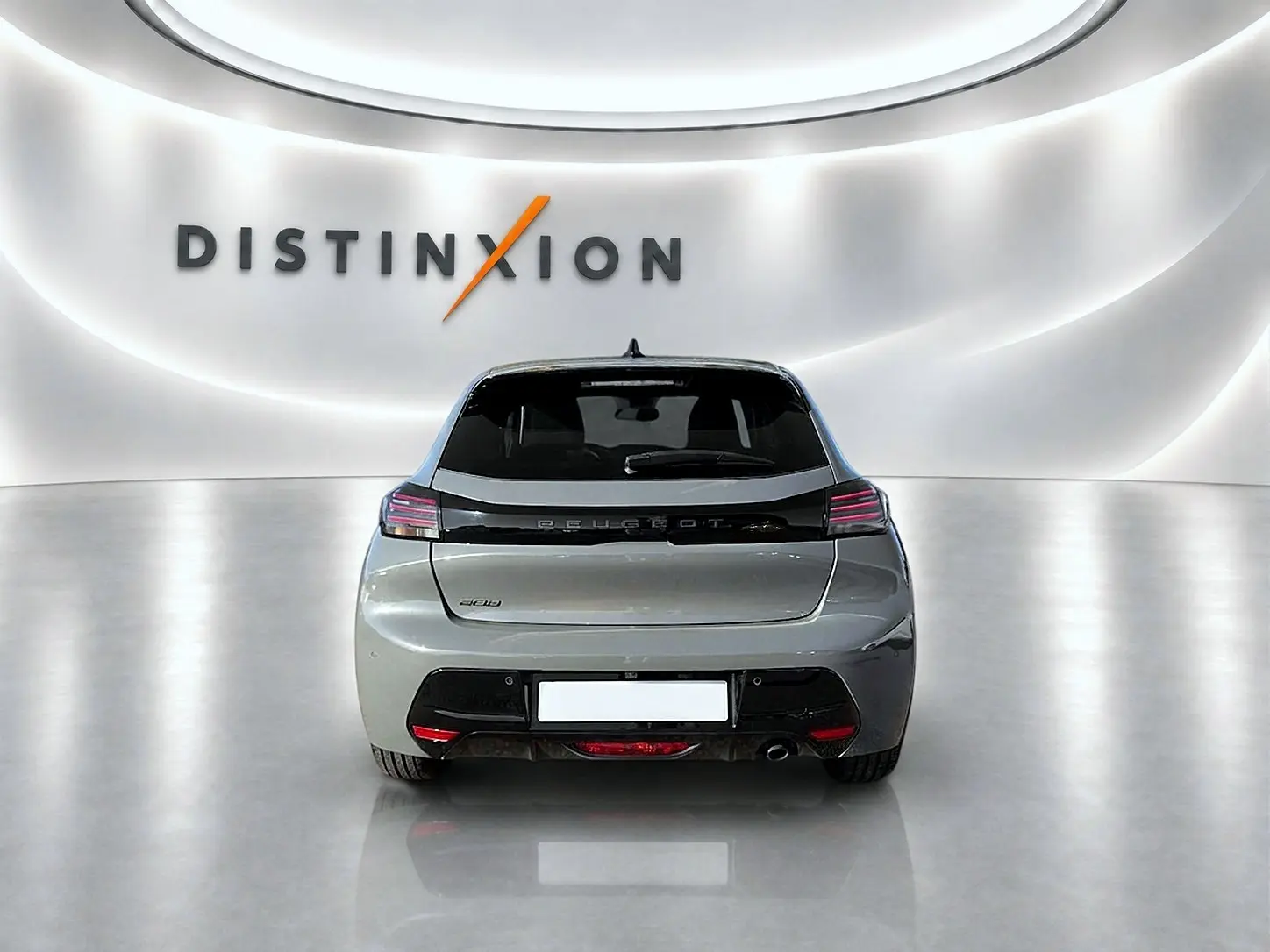 Vue arrière d'une Peugeot 208 gris selenium dans un showroom lumineux avec logo Distinxion en arrière-plan.