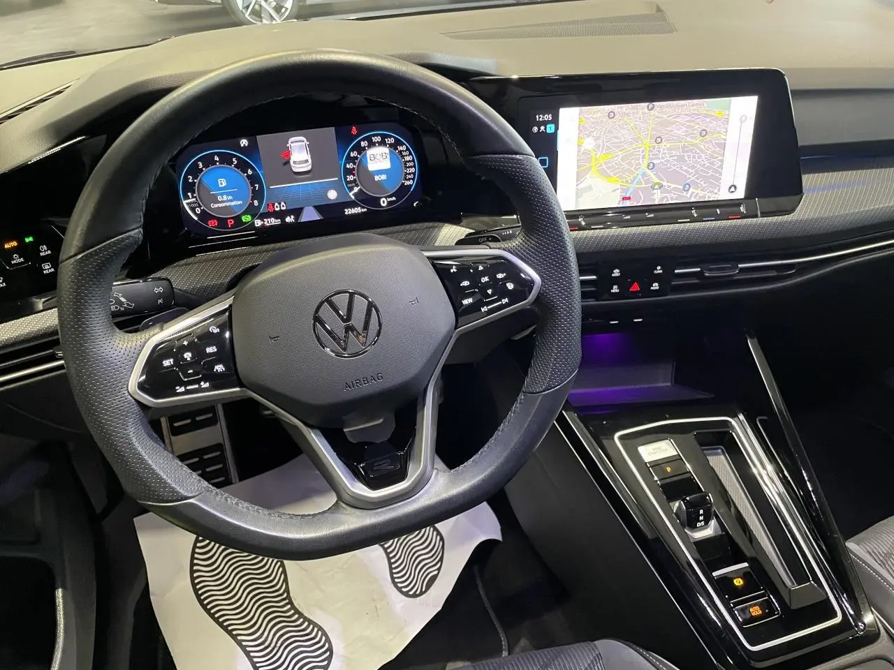 Vue intérieure centrée sur le volant cuir multifonctions et le tableau de bord digital de la Volkswagen Golf VIII R-Line Black.
