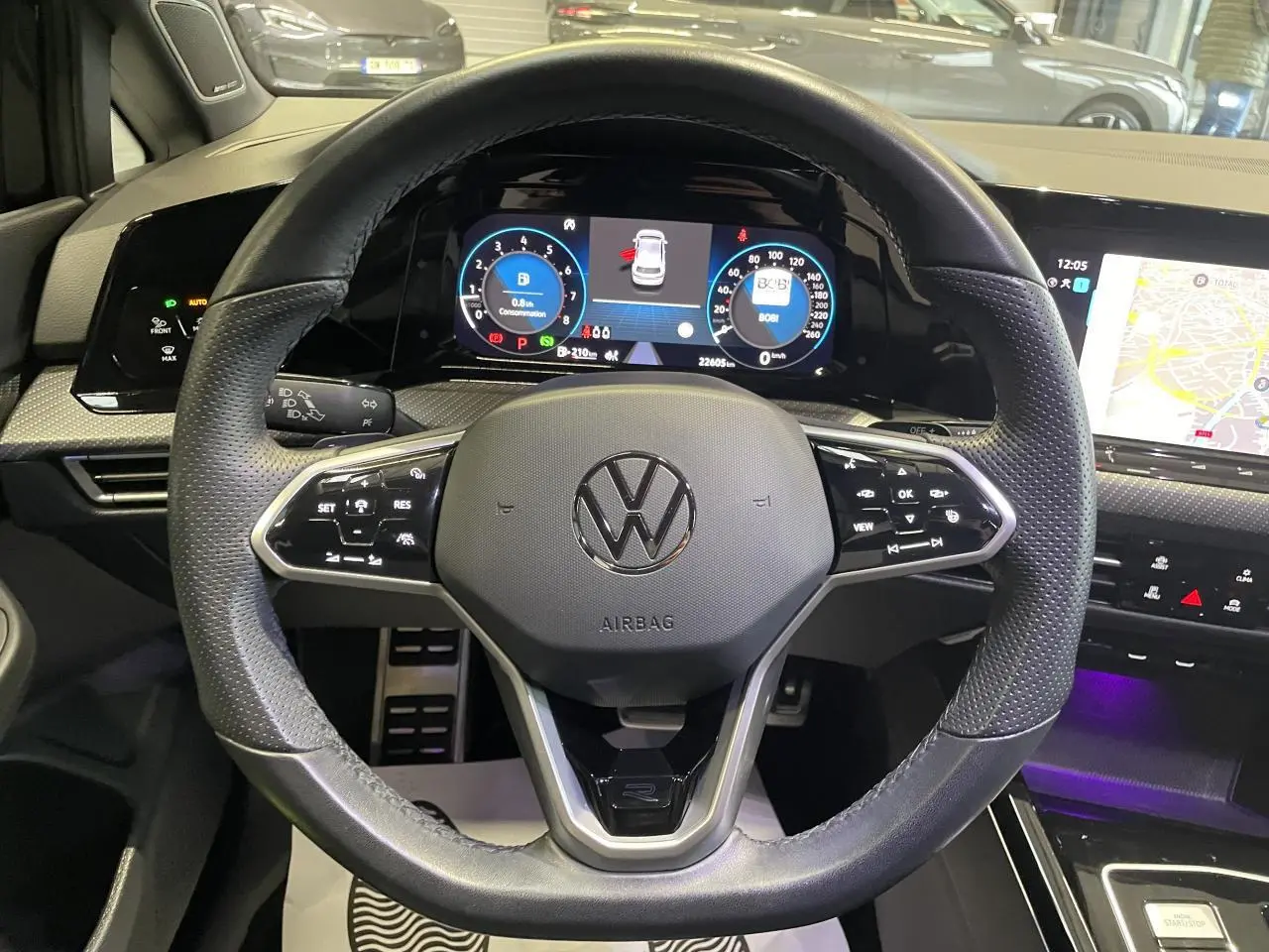 Vue intérieure centrée sur le volant cuir multifonctions noir avec tableau de bord digital et écran tactile de la Volkswagen Golf VIII R-Line Black.
