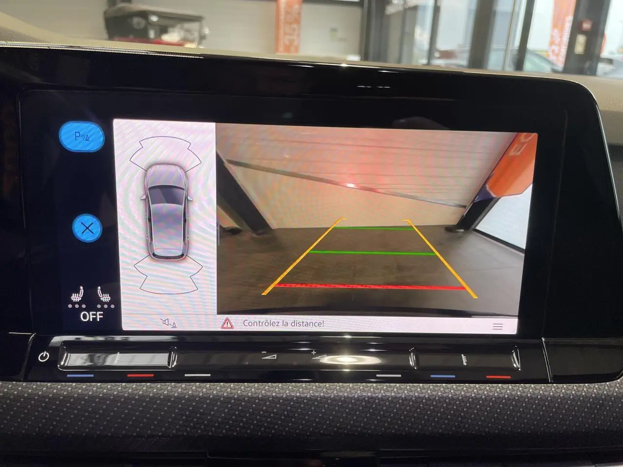 Écran de caméra de recul et capteurs de stationnement de la Volkswagen Golf 8 R-Line noire, vue intérieure du tableau de bord.