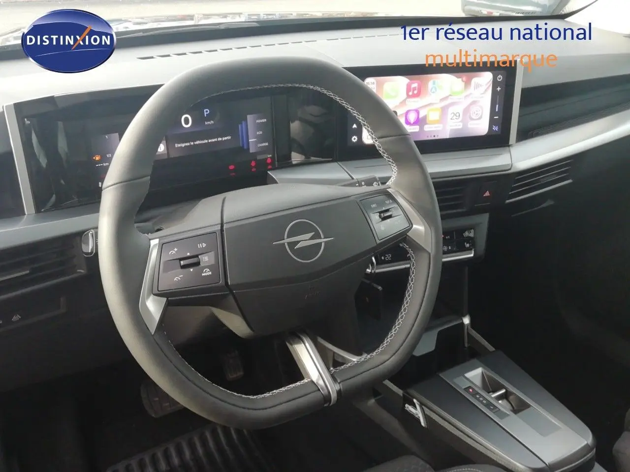Vue intérieure centrée sur le volant noir de l'Opel Frontera 2025 avec tableau de bord numérique et écran tactile.