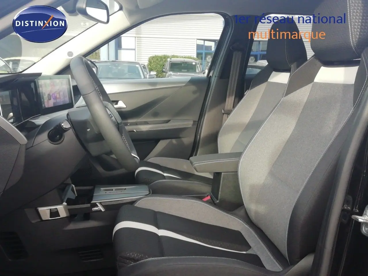 Vue intérieure côté conducteur de l'Opel Frontera 2025, sièges tissu gris noir avec accoudoir central.