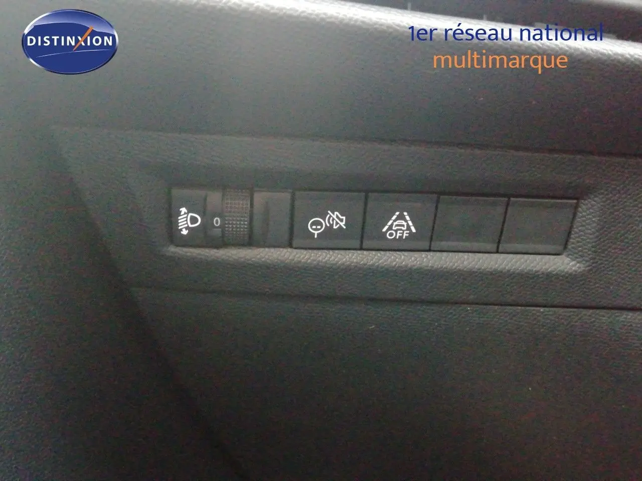 Gros plan sur les commandes de réglage des phares et aides à la conduite dans l'habitacle de l'Opel Frontera noir Karbon.
