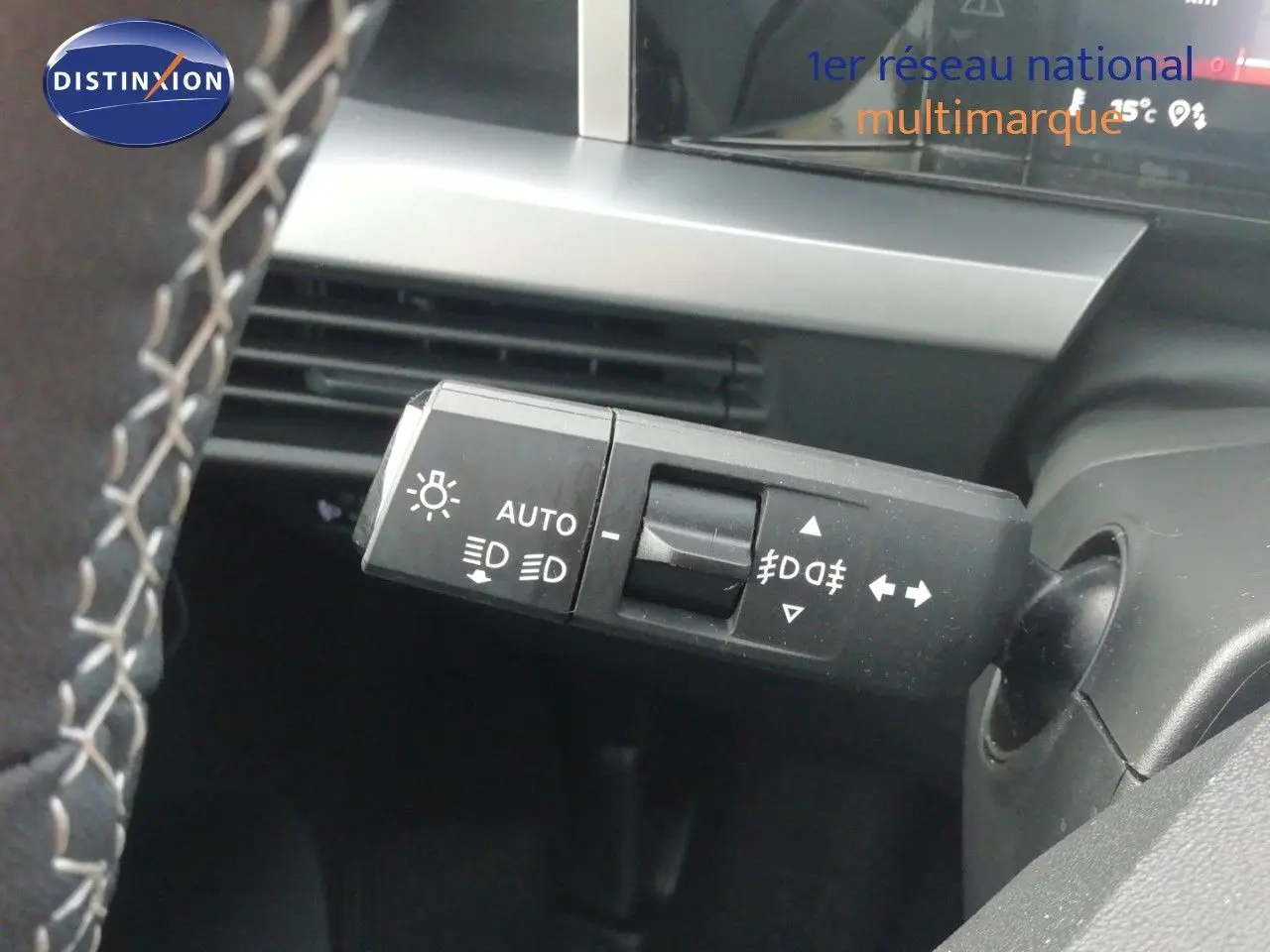 Gros plan sur la commande des phares et clignotants à gauche du volant dans l’habitacle gris noir de l’Opel Frontera 2025 noir Karbon.