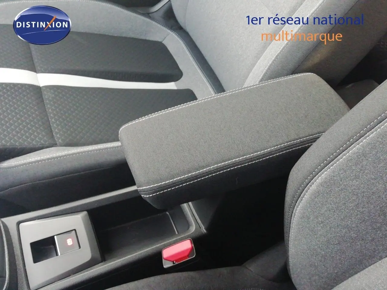 Détail de l'accoudoir central et des sièges en tissu gris foncé de l'intérieur de l'Opel Frontera 2025.