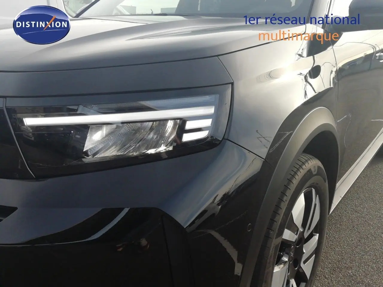 Gros plan sur l'avant droit de l'Opel Frontera 2025 noir Karbon, mettant en valeur son phare LED et sa jante bi-ton.