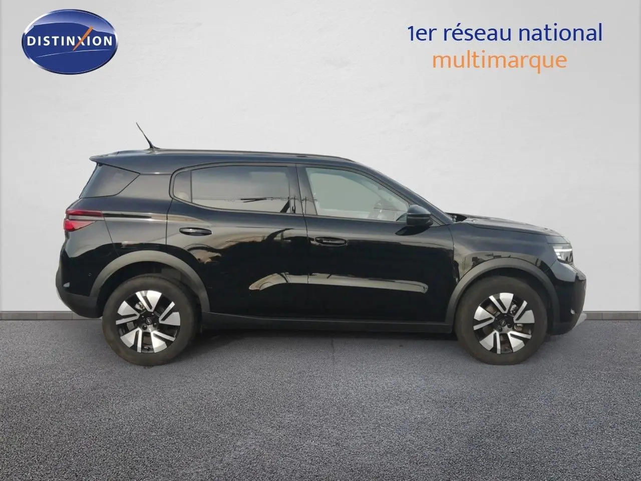 Vue de profil côté gauche d’un Opel Frontera 1.2 Turbo Hybrid noir Karbon avec jantes bi-ton et vitres teintées.