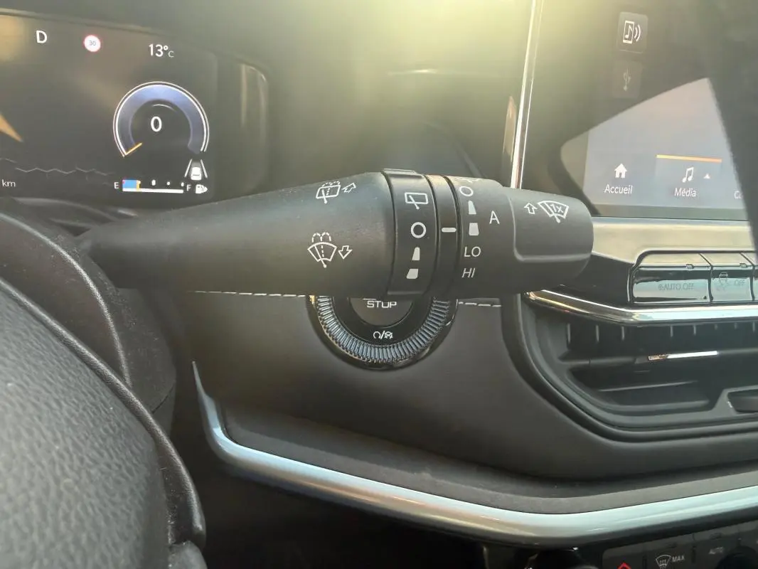 Gros plan sur la commande des essuie-glaces du tableau de bord du Jeep Compass 2024, intérieur noir avec écran tactile.