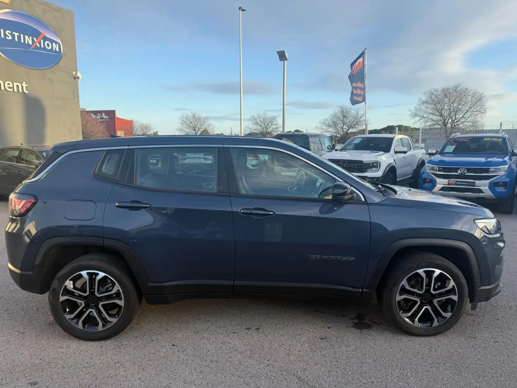 Vue latérale droite d'un Jeep Compass bleu 2024 avec jantes alliage 18 pouces et lignes robustes.