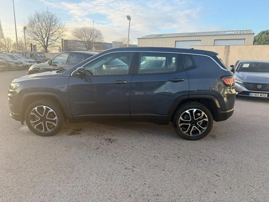 Jeep Compass bleu vue de profil côté gauche, avec jantes alliage 18 pouces et rétroviseurs électriques.