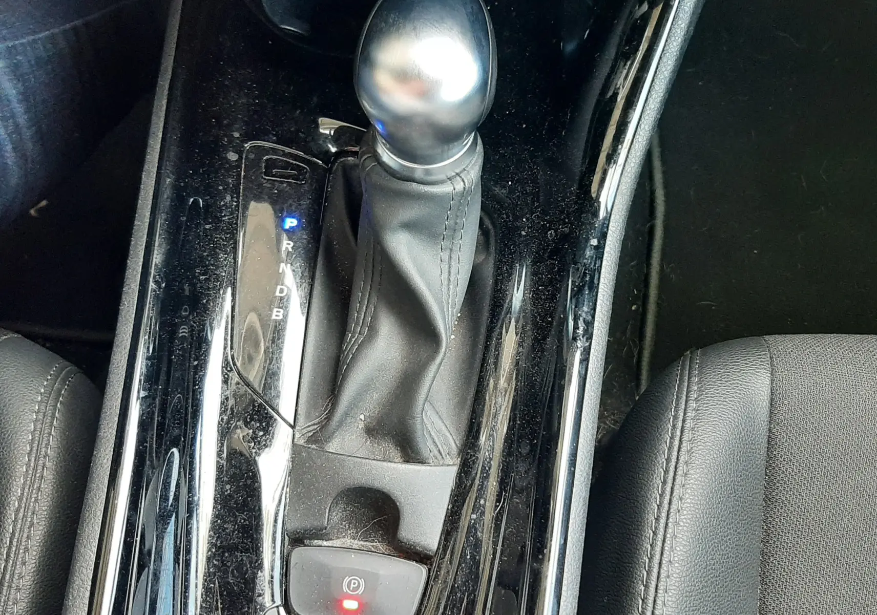 Vue rapprochée de la console centrale noire du Toyota C-HR 1.8 Hybrid 2023, mettant en valeur le levier de vitesse automatique.