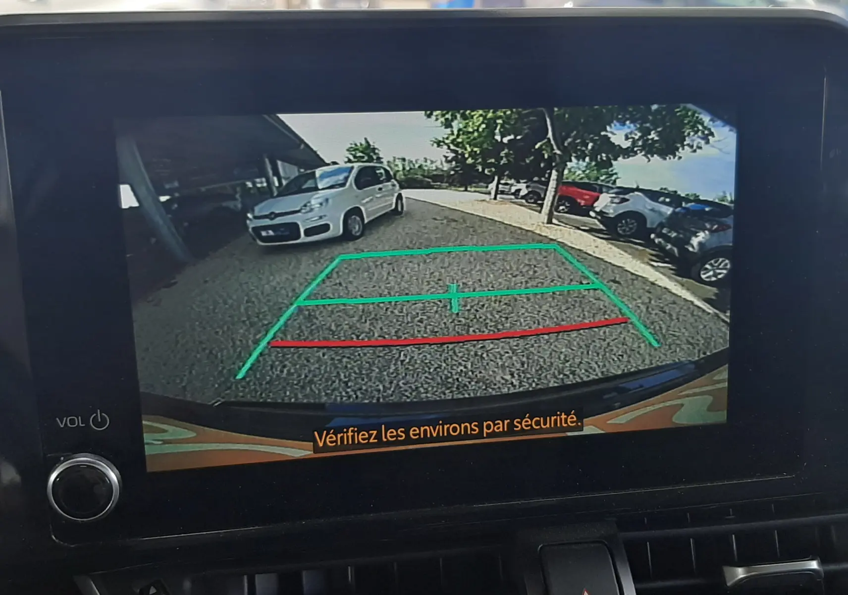 Écran de caméra de recul du Toyota C-HR noir 2023 montrant l'arrière avec lignes de guidage vertes et rouges.