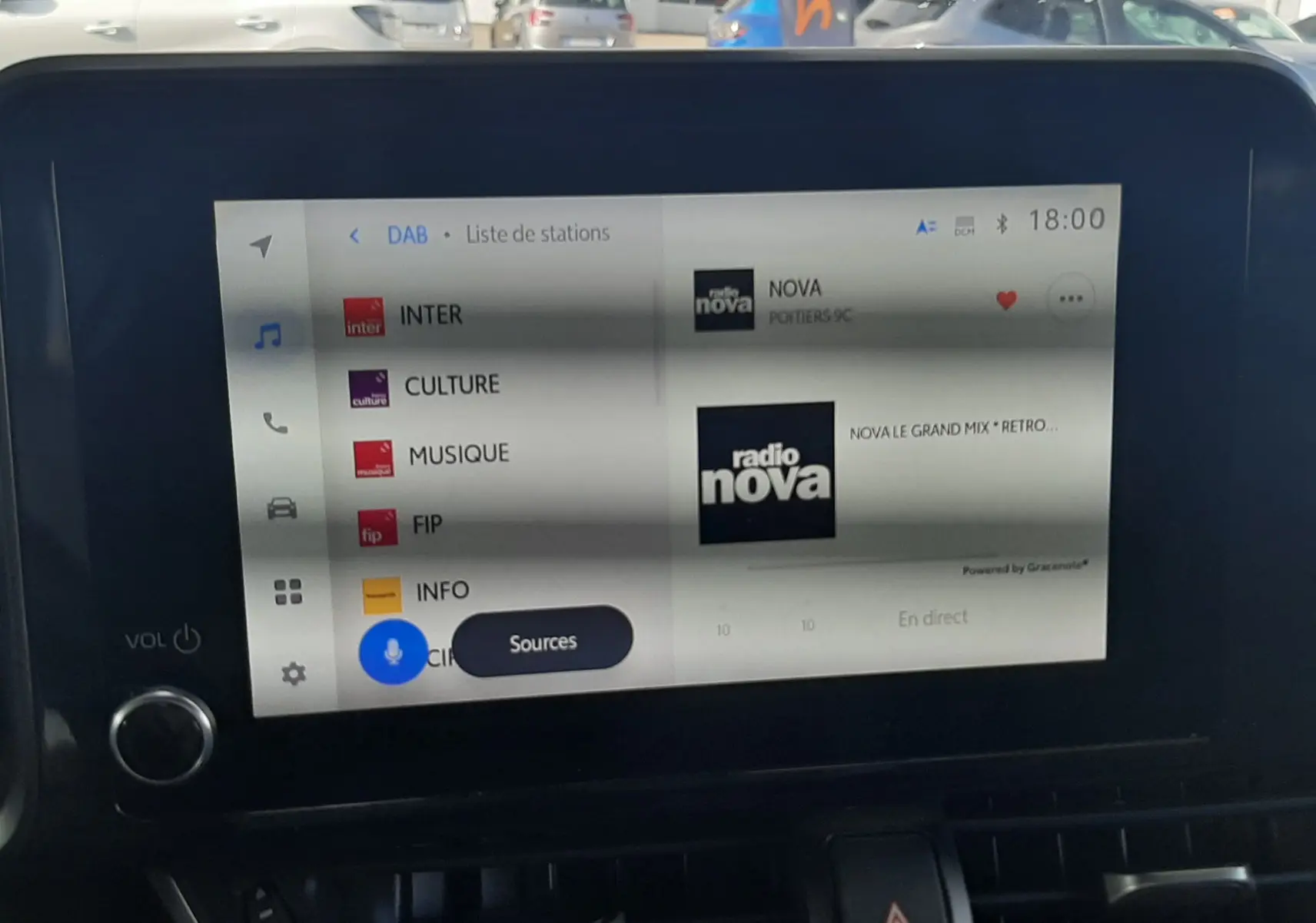 Vue rapprochée de l'écran multimédia du Toyota C-HR 1.8 Hybrid 122 Design noir 2023, affichant la liste des stations radio.