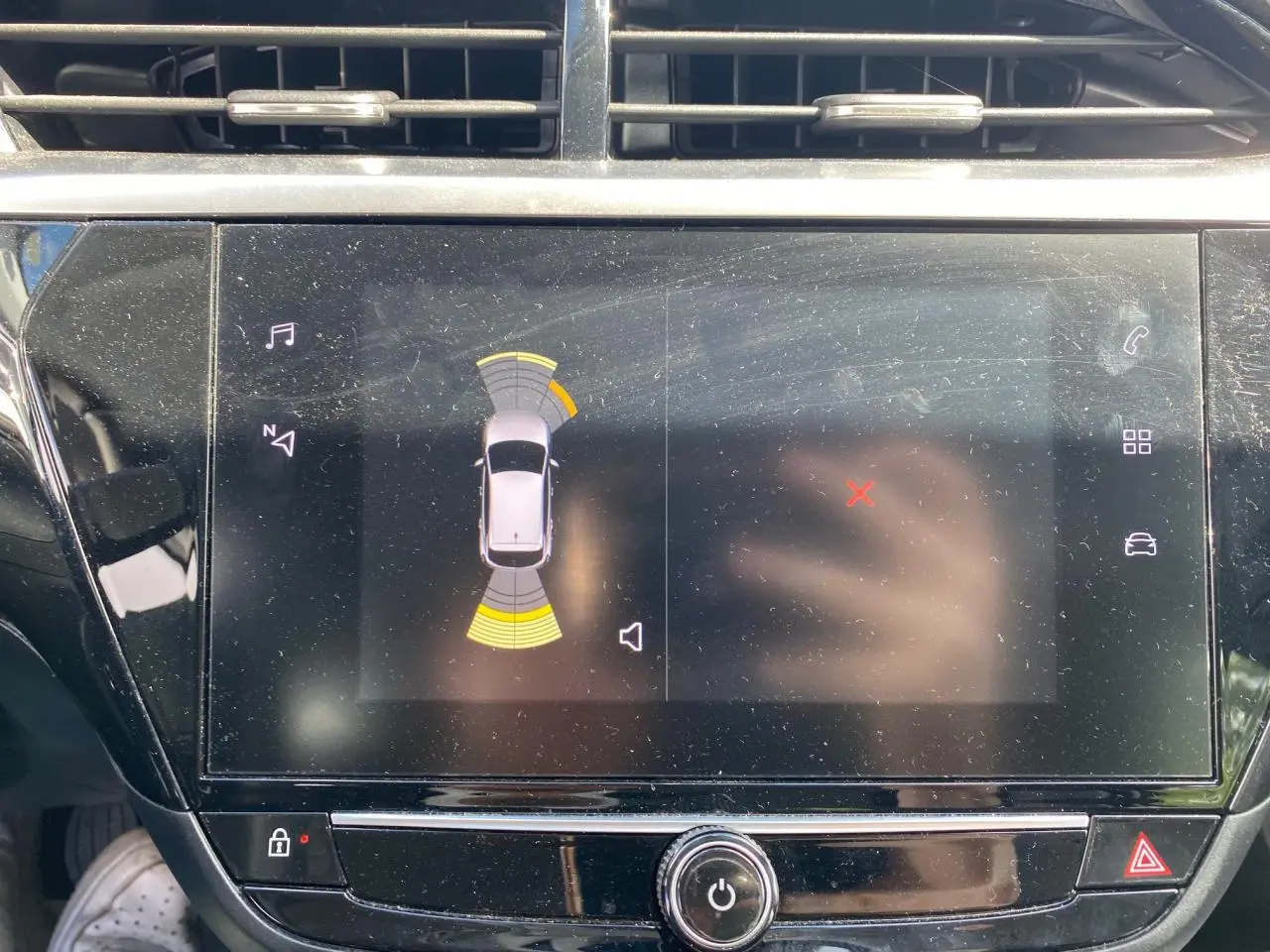 Écran tactile central de l’Opel Corsa 1.2i Turbo 2021 affichant l’aide au stationnement avec capteurs avant et arrière.