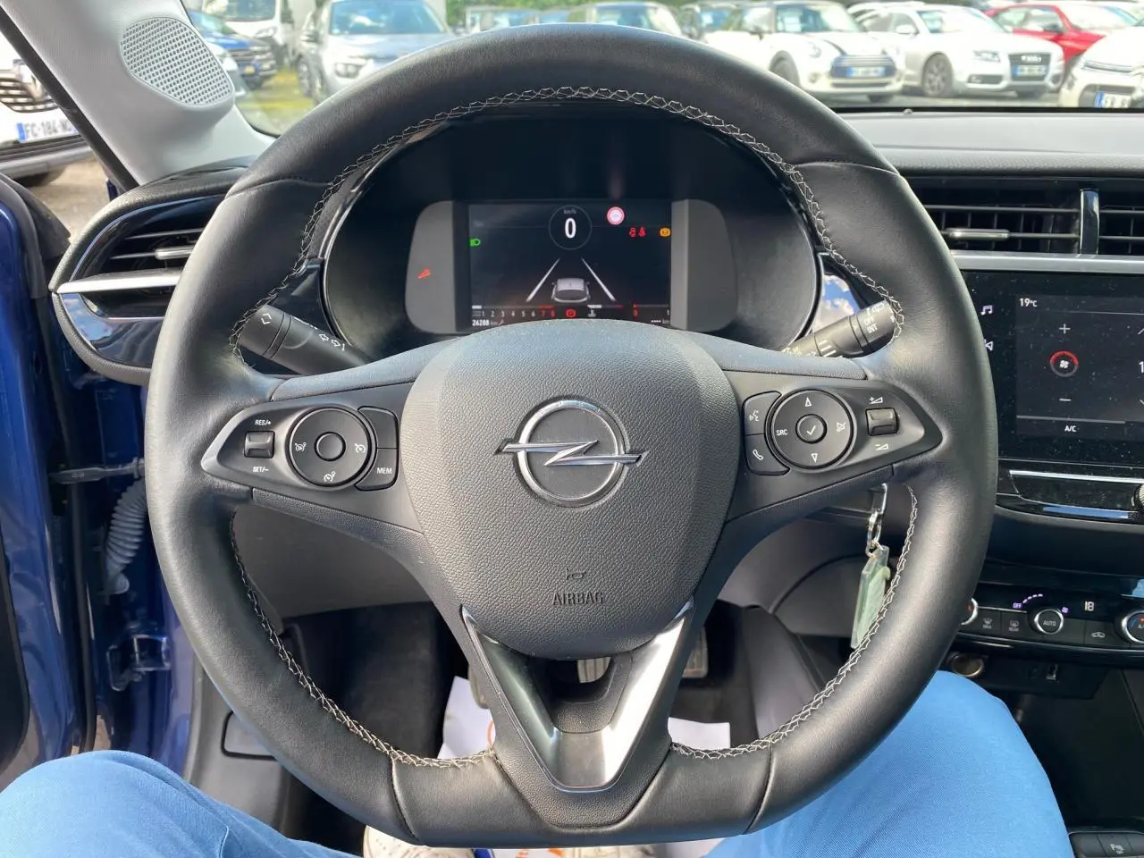 Volant en cuir multifonction de l’Opel Corsa bleu nautique, vue centrée sur le tableau de bord digital et commandes au volant.