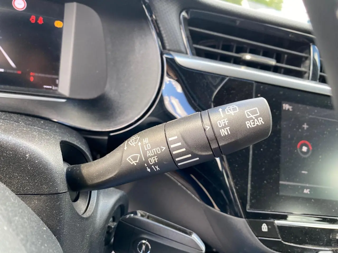 Gros plan sur la commande d’essuie-glace à gauche du volant dans l’habitacle noir brillant de l’Opel Corsa 2021.