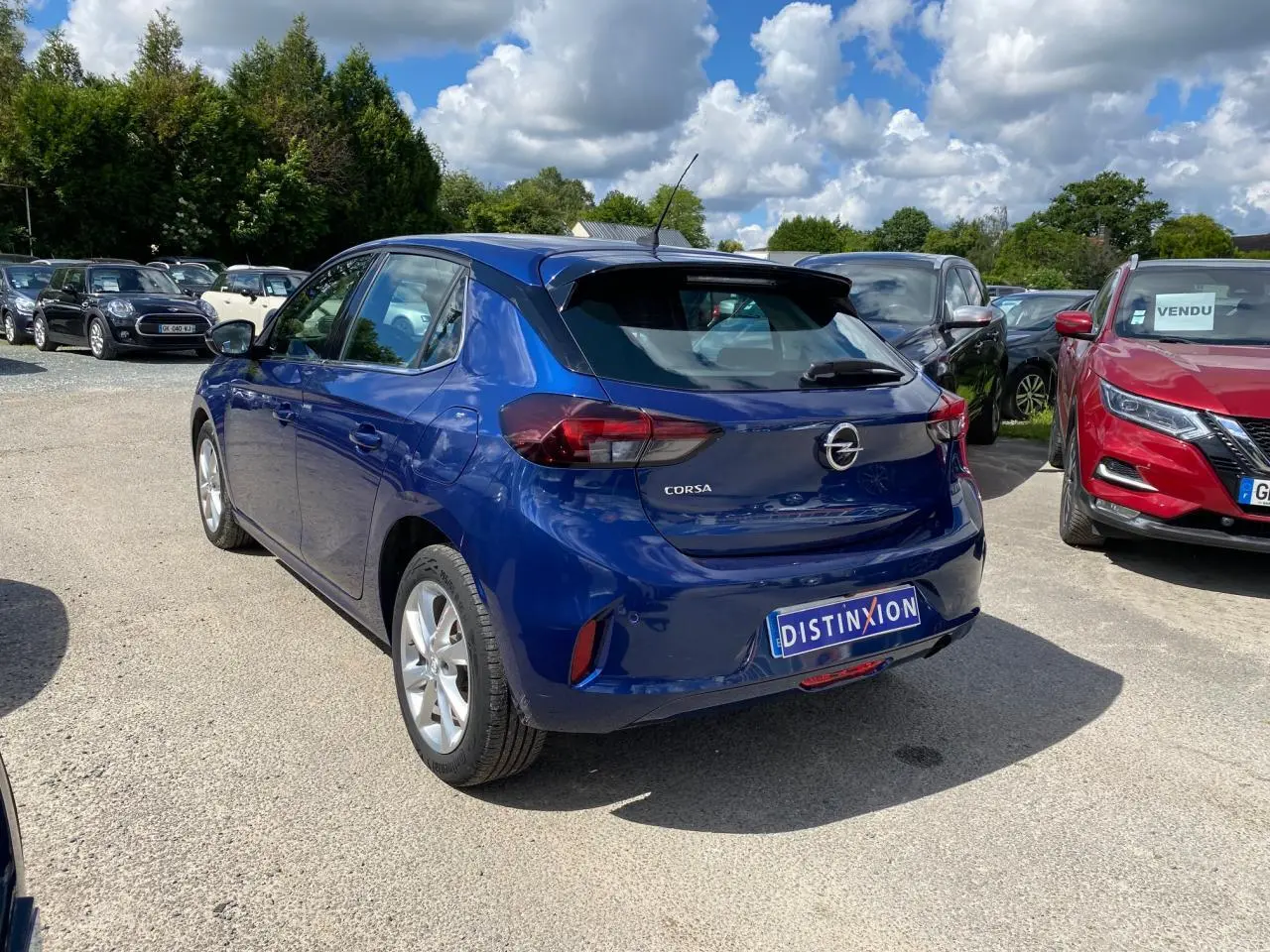 Vue 3/4 arrière d'une Opel Corsa bleu nautique garée en extérieur avec jantes alliage argentées.