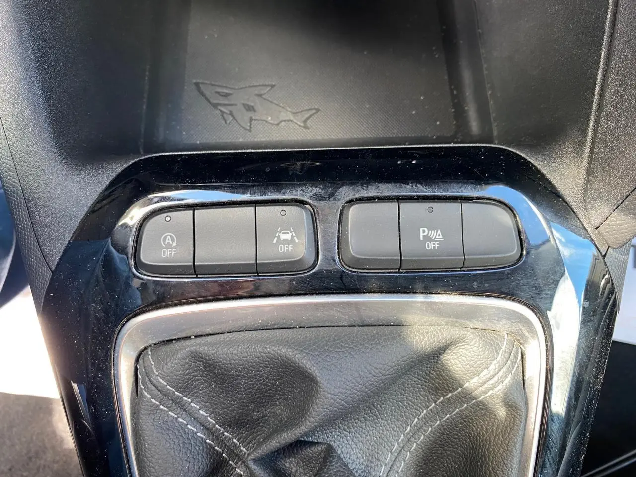 Gros plan sur la console centrale de l’Opel Corsa bleu nautique, montrant le soufflet de levier de vitesse et les boutons de contrôle.