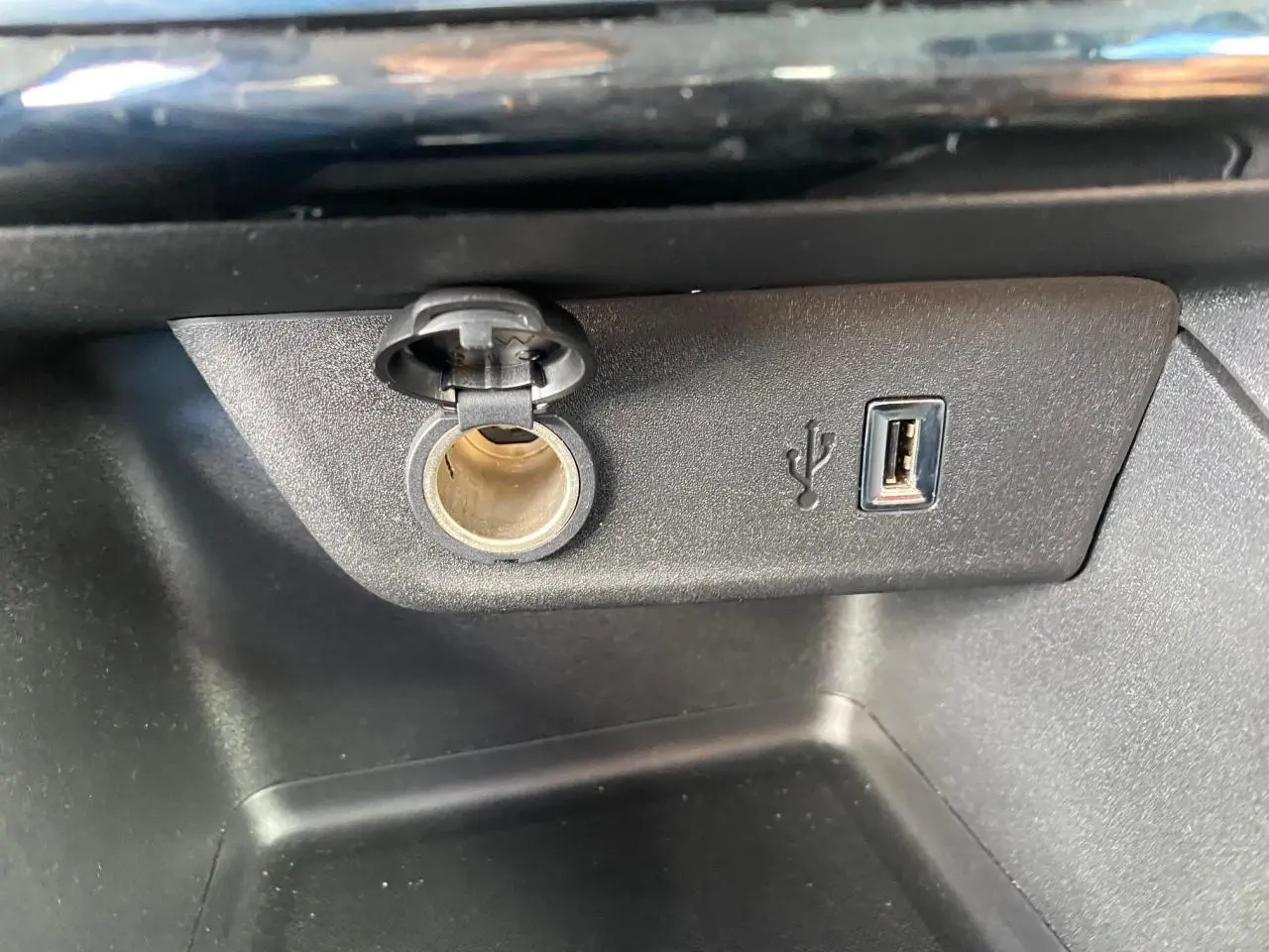 Gros plan sur la prise 12V et port USB intégrés dans la console centrale de l’Opel Corsa 1.2i Turbo.