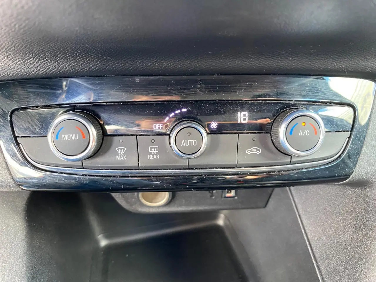 Gros plan sur la commande de climatisation automatique de l’Opel Corsa 1.2i Turbo 2021, avec affichage digital et boutons rotatifs.