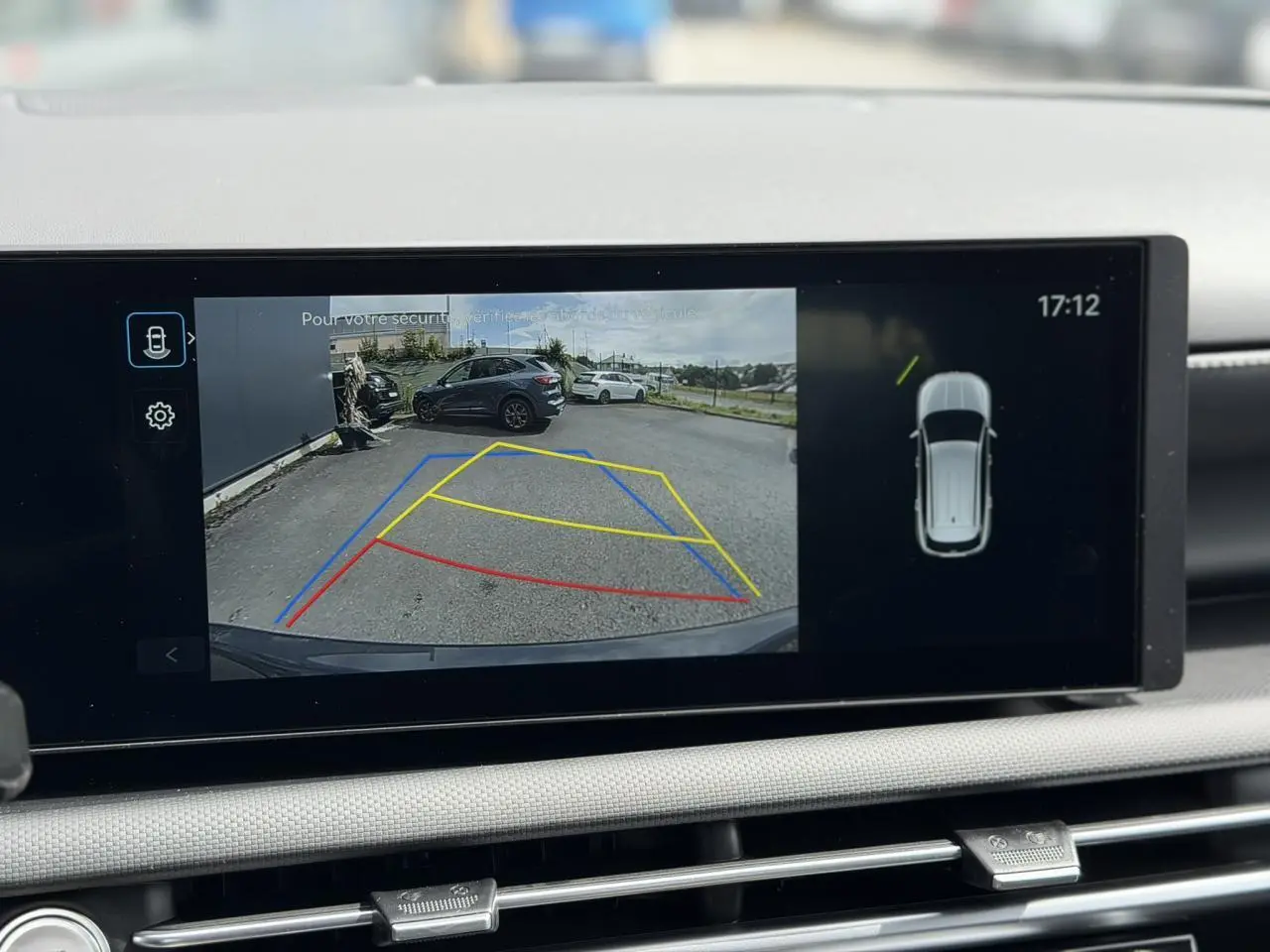 Vue écran multimédia montrant la caméra de recul du Hyundai Tucson Ecotronic Gray avec lignes de guidage colorées.